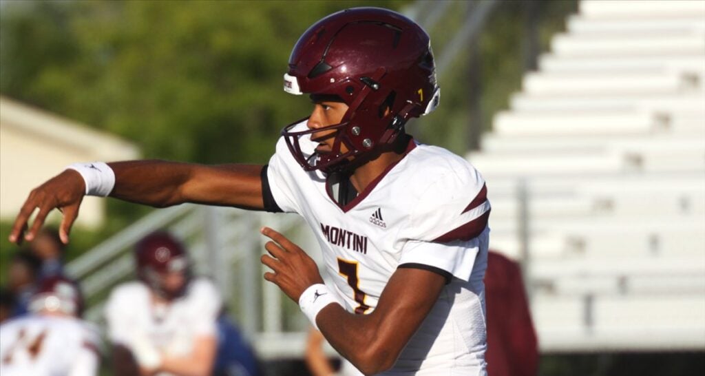 Israel Abrams in a white and maroon Montini uniform pointing downfield before a throw